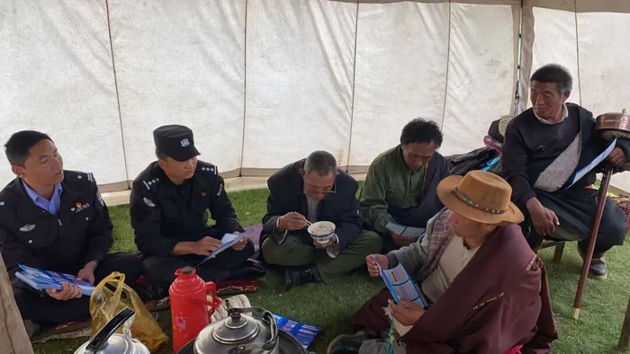 2021年6月，额旺格拉（左2）在若尔盖县麦溪乡远牧点帐篷内开展法治宣传工作。