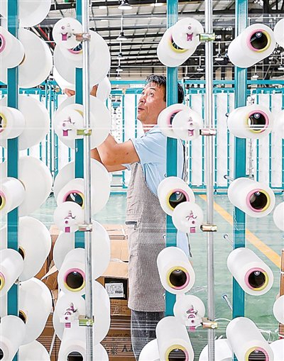 工人在毕节宏盛纺织科技有限公司纺织车间作业。李华摄