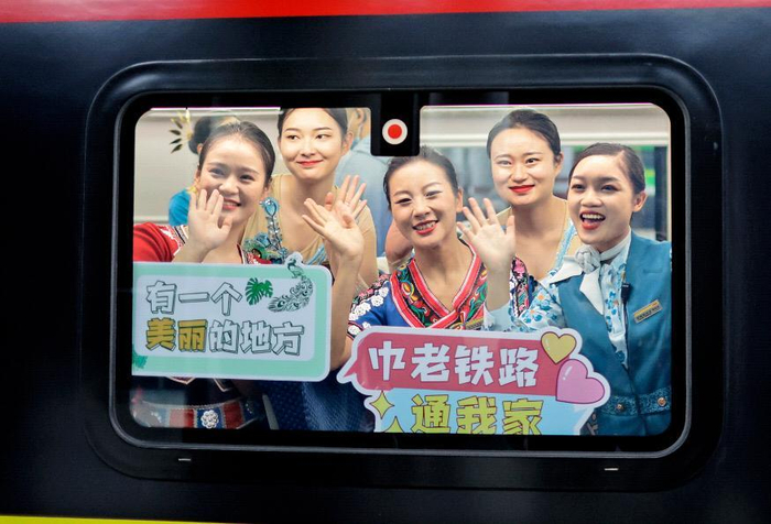 中老铁路通车首日，乘务员举牌庆祝。 记者 陈飞 摄