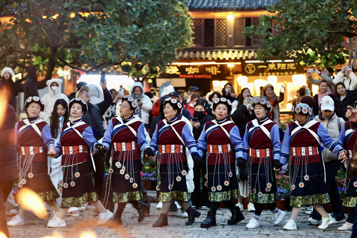 夜幕降临，丽江古城四方街，来自各地的游客与纳西族人们一起跳着欢乐的打跳。陈飞 摄