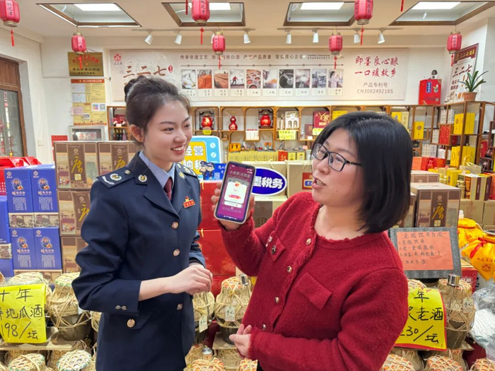 近日，国家税务总局青岛市即墨区税务局税务干部到当地特色商圈宣传有奖发票活动，辅导消费者开票并参与抽奖。冯国滨 周梦园/摄