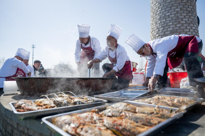 　　3月20日，厨师们在呼和浩特黄河开河民俗文化周活动现场炖鱼。新华社记者 连振 摄