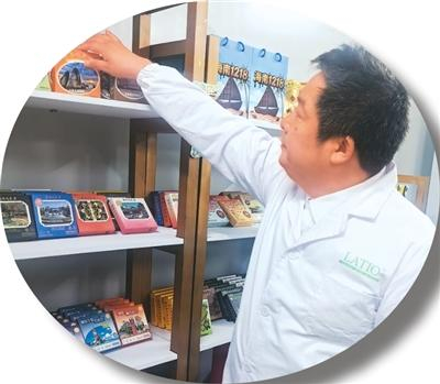 图为孟新力在公司展柜前展示巧克力成品。受访者供图