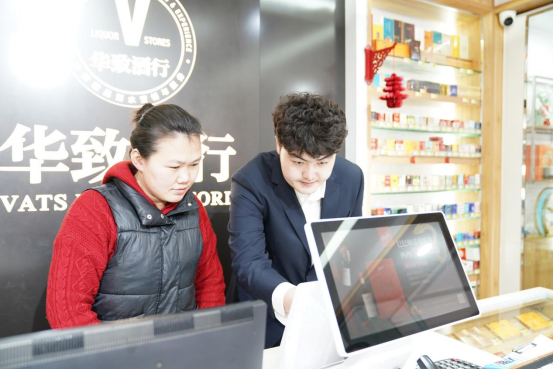 图为工作人员指导零售户运用数字化设备分析销售数据（东平烟草供图）