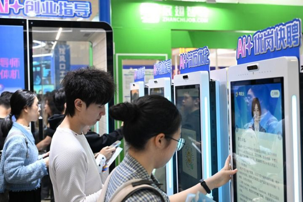 △ 3月15日，在“百万英才汇南粤”2026年春季大型综合招聘会现场，应聘者在智能设备上查询岗位信息、优化简历。