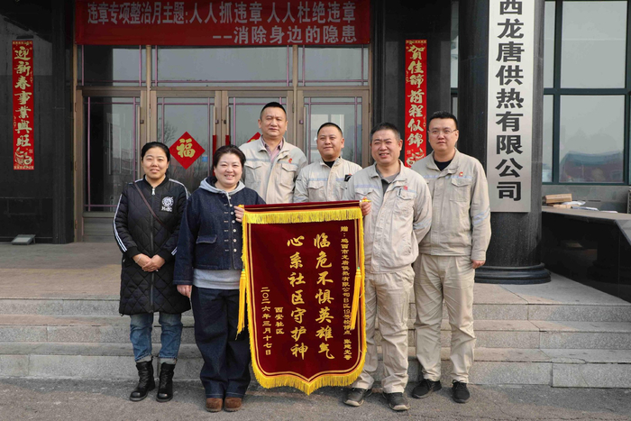 社区工作人员给张建光（右二）送锦旗