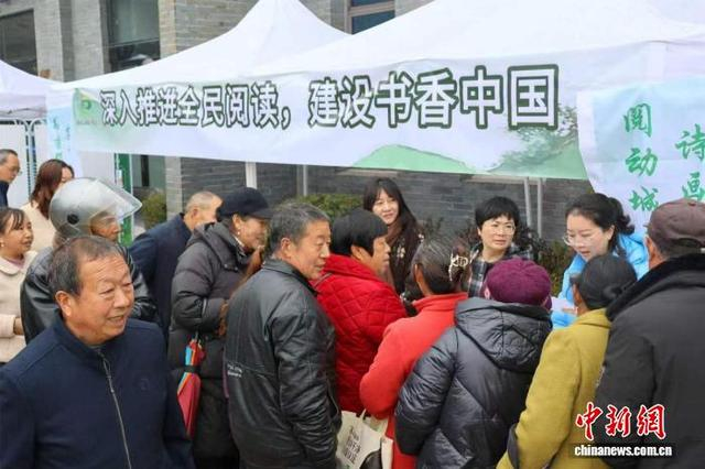 “开往春天的图书车”送书下乡，吸引村民驻足咨询。张国荣 摄