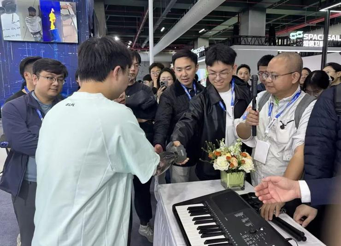 佩戴强脑智能假肢的工作人员与探展团成员握手
