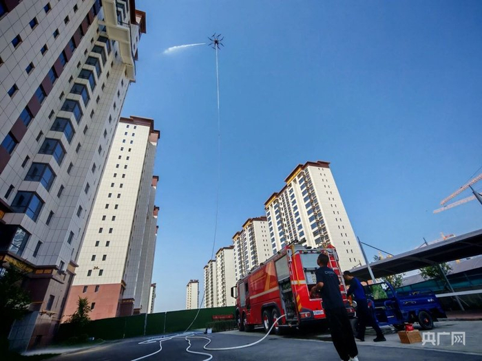 消防无人机挂载消防水带模拟高空灭火 （央广网发 新疆三和无人机研究院有限公司供图）