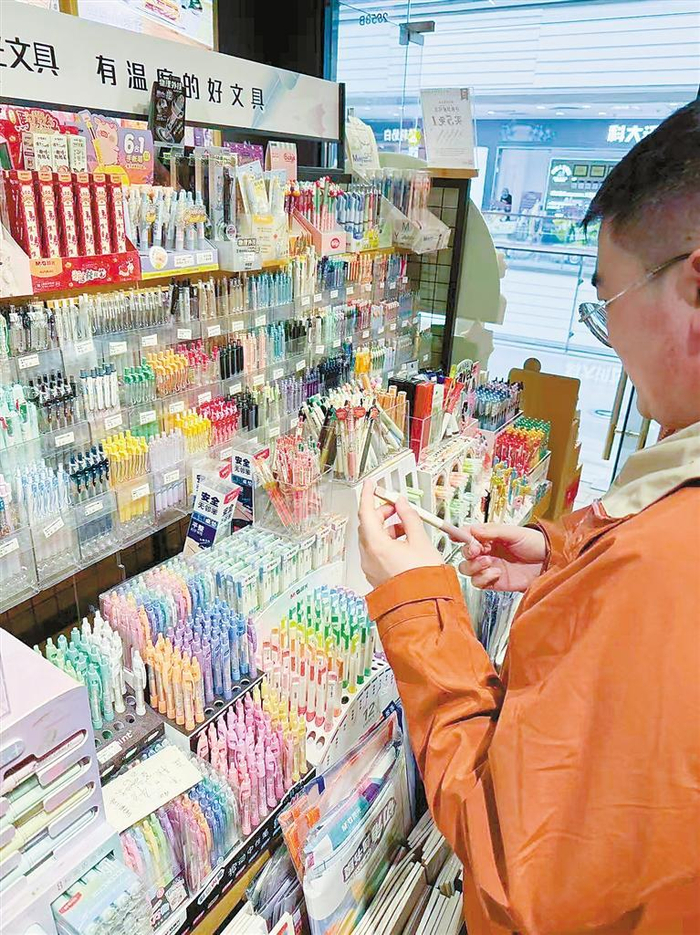     市民张先生在文具店选购孩子所需文具。本报记者 李博楠 摄