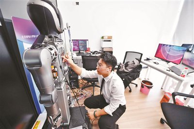 耀行科技创始人周奇民在邮创空间办公室内，检测机器人电机线路