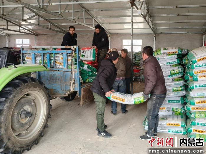 库伦旗诚实农机种植专业合作社正组织人员为农户发放农资。李明月 摄