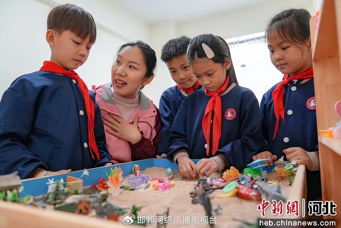 图为学校心理教师正在通过沙盘推演为学生进行心理疏导。 王倩倩 摄