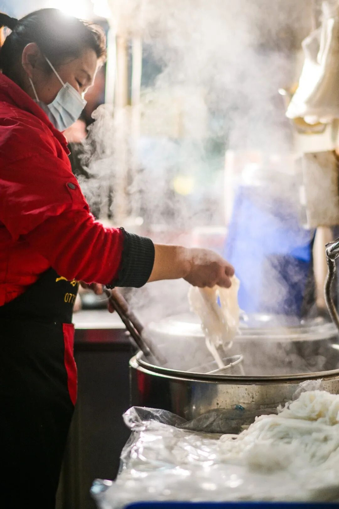 在七星区普陀路一家米粉店里，老板娘正在冒米粉。记者滕嘉 摄