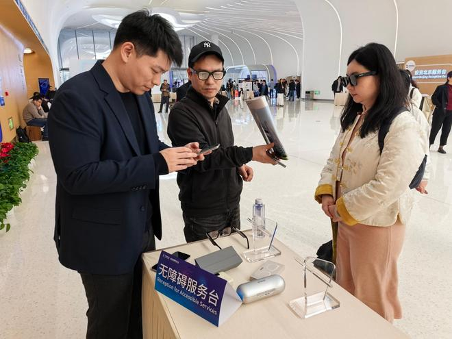 　　视障人士郭家乐（右一）在2026中关村论坛年会上试戴智能眼镜。新华社记者 夏子麟 摄