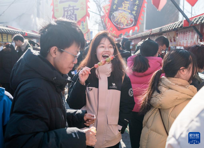 在北京沙河大集，一名女孩在品尝特色小吃。新华社记者 才扬摄
