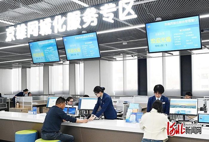 3月27日，在雄安新区政务服务中心京雄同城化服务专区，工作人员为办事人员提供服务。 河北日报记者 刘光昱摄