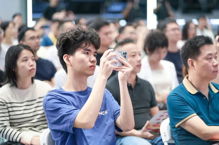 现场气氛热烈，与会者听得津津有味，时不时拿起手机记录。