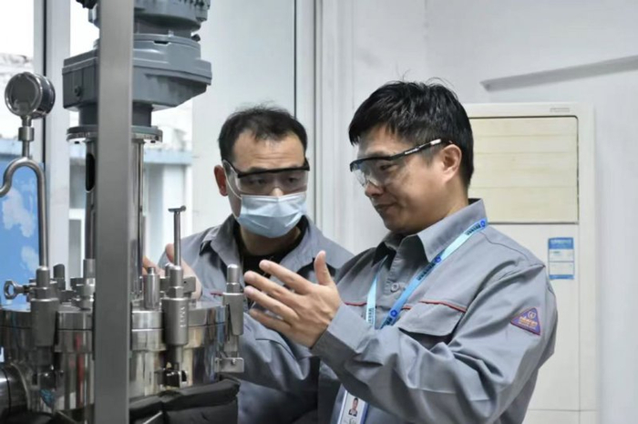 （联创生物董事长（右）与技术人员进行交流）