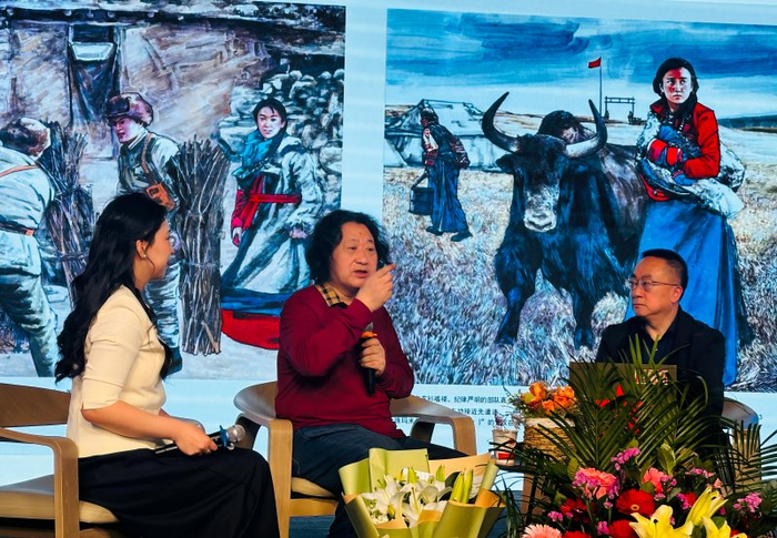 中国美术家协会连环画艺术委员会副主任、兵团美术家协会名誉主席尤山（中）正在向读者讲述绘画过程中遇到的难题。李萍 摄