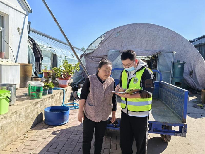 监测户钟淑霞正在与张迪核对果蔬信息