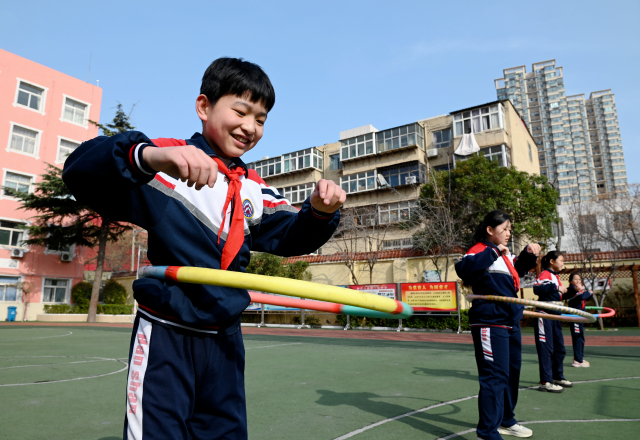 学生在操场上玩转呼啦圈。中国教育报-中国教育新闻网通讯员通讯员 周绍宗 摄