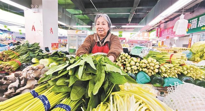     3月25日，在七师天北经开区牛街农贸市场，蔬菜店主陈蓉在整理刚到的新鲜蔬菜。    兵团日报常驻记者  郭雪雪  摄