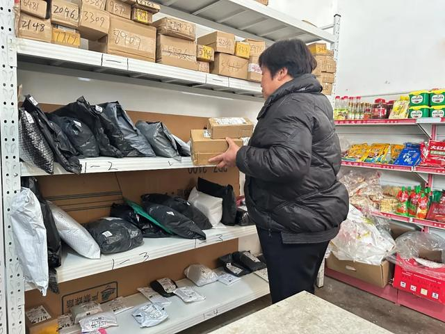 （杨海娥正在乡村驿站取快递。刘地|摄）