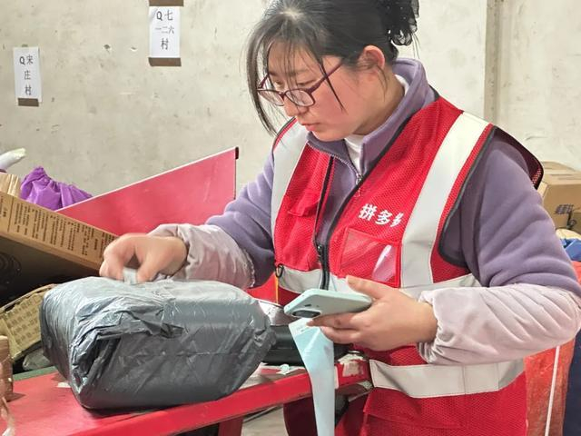 （分拣员正在分拣入村快递。刘地|摄）