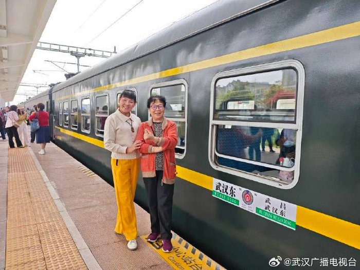   游客在4818次列车前合影留念。新华社记者 张阳 摄