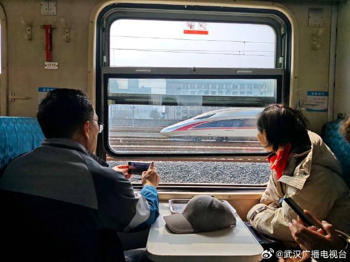   武汉市民邱先森在拍窗外的高铁。新华社记者 张阳 摄