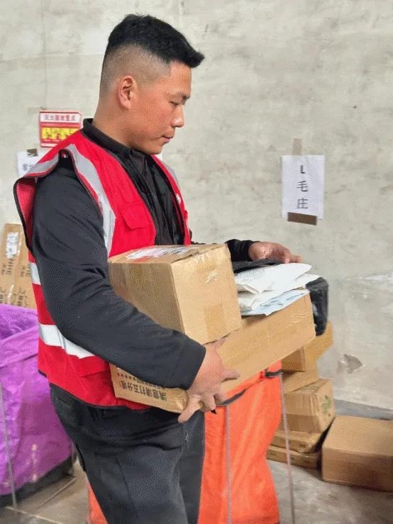 （王修宇正将快递分拣至对应村点。刘地|摄）