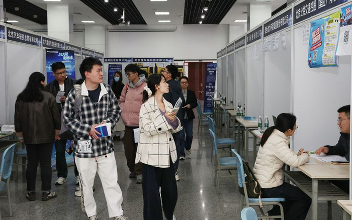 高校学子在了解用人单位的招聘信息。北京市人社局供图