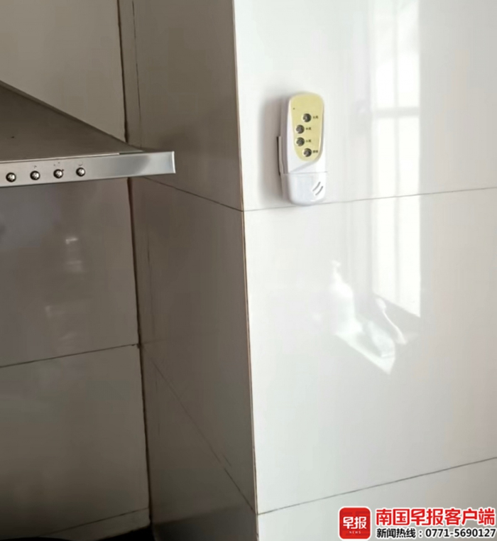 ▲李女士家的抽油烟机经维修后，控制器被贴在墙上，属于违规改装。