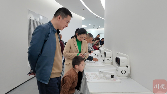 2026宜宾机器人大会吸引了不少孩子前来和下棋机器人对弈。李婷 摄