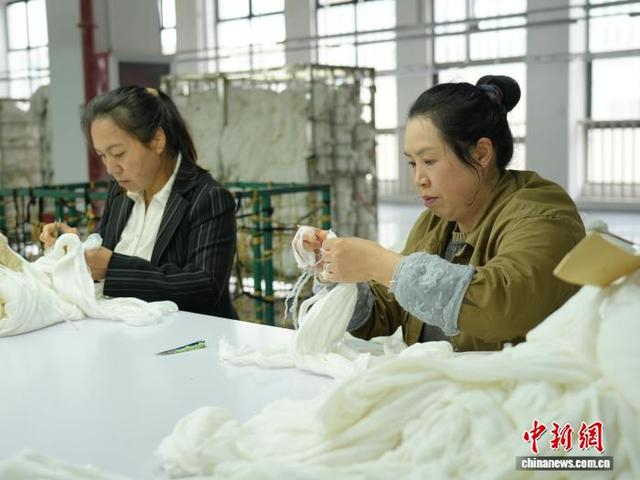 图为3月31日，工人在纺织企业车间的生产线上作业。石小杰 摄 