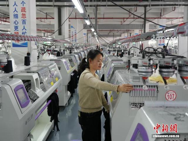 图为3月31日，工人在纺织企业车间的生产线上作业。石小杰 摄 