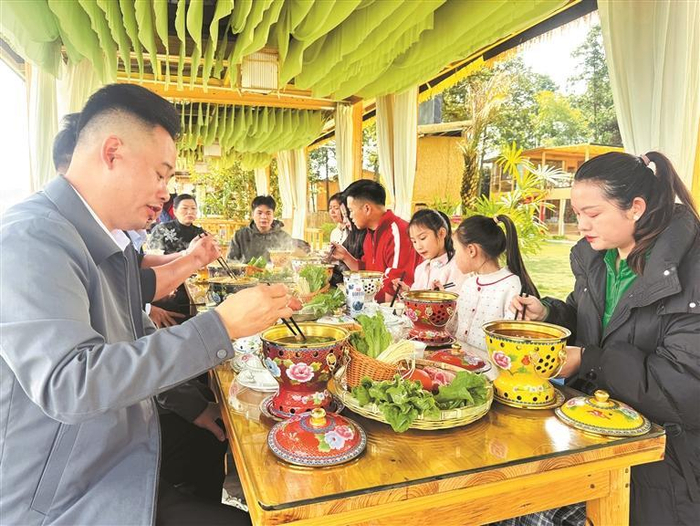 游客在桂花台茶苑品尝单人小火锅。  （贵州黎墨旅游有限公司供图）