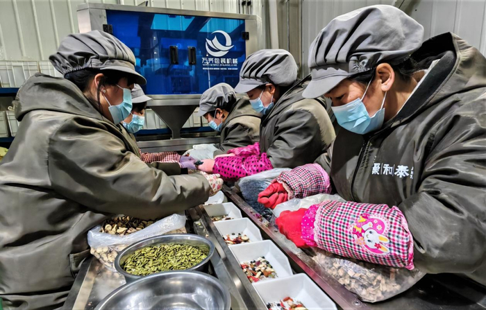 图为工人们在精心挑选配送商品