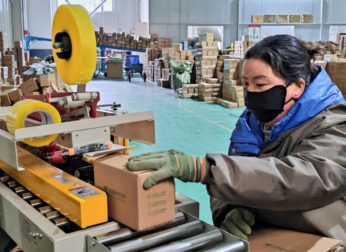 图为聚和泰公司商品包装车间工人们正在忙碌打包