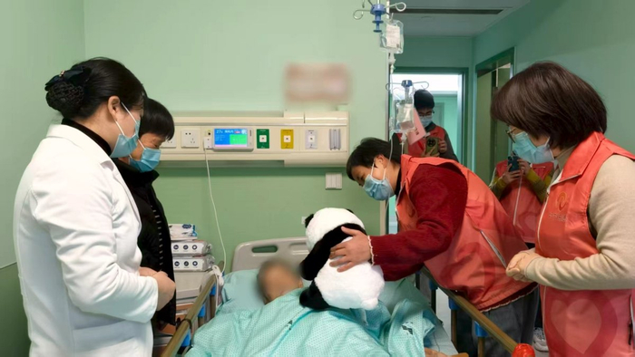 志愿者团队给杨阿姨送熊猫玩偶。受访者供图
