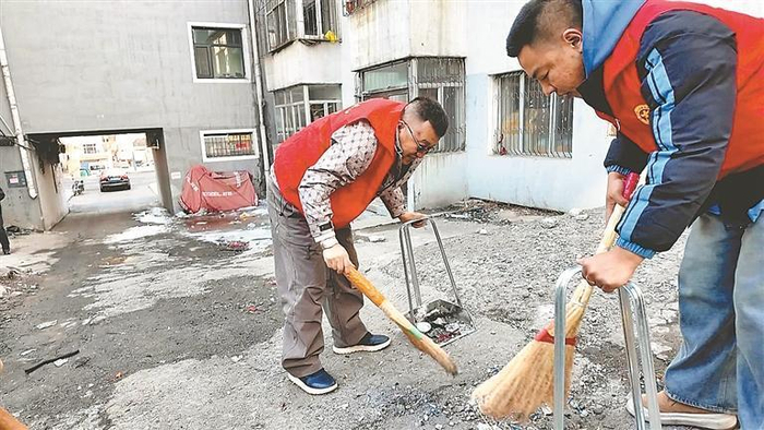     志愿者们清理小区角落垃圾。本报记者 杜怀宇摄