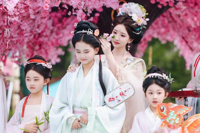（图2：花西子好气色彩妆大使毛晓彤正在为孩子“簪花送福”）