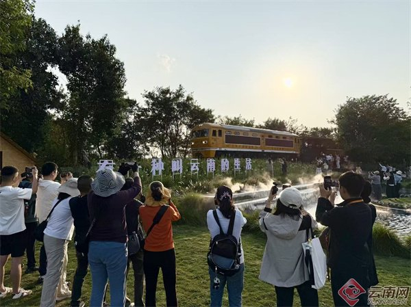 游客在建水晨夕花园拍摄米轨小火车经过