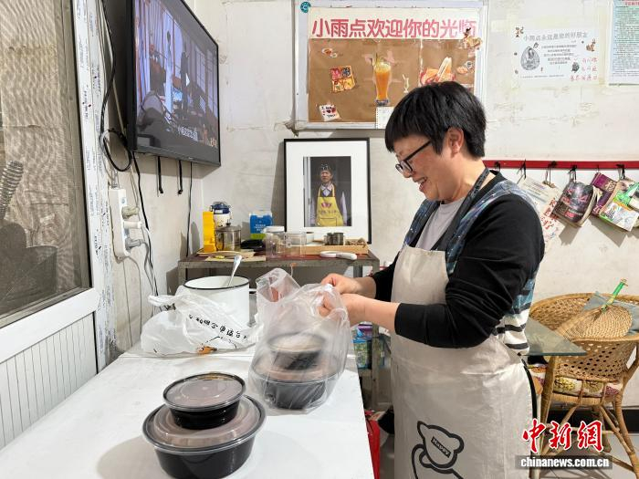  4月4日，“小雨点”饮品店另一位运营人王青泓在店内打包猪扒饭。陈静 摄