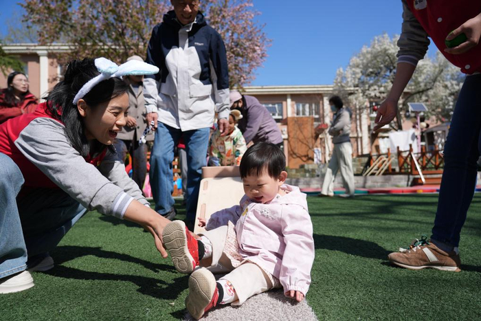 　　4月1日，在北京市第五幼儿园亲子托育活动现场，家长和孩子在老师引导下参加户外活动。新华社记者 谢晗 摄