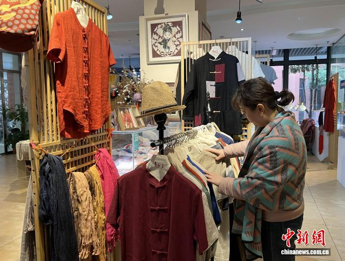  2月5日，重庆市民在“壹秋堂”非遗工坊内挑选夏布产品。中新社记者 钟旖 摄