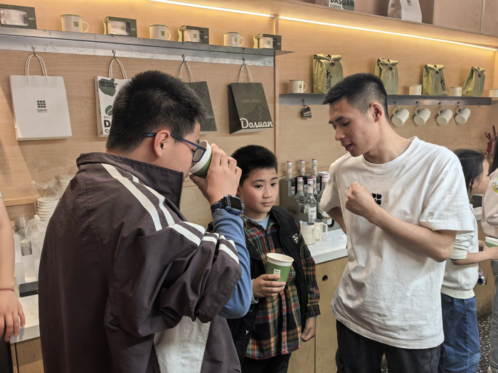 榜样青年CSA社区里，咖啡师在向青少年介绍大蒜咖啡原理。