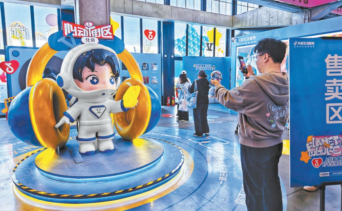 歌迷在THE BOX打卡“小北斗”雕塑。本报记者 方非摄