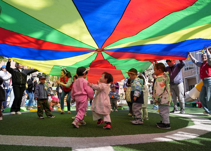 2026年4月1日，在北京市第五幼儿园亲子托育活动现场，家长和孩子在老师引导下参加户外活动。 新华社记者 谢晗 摄